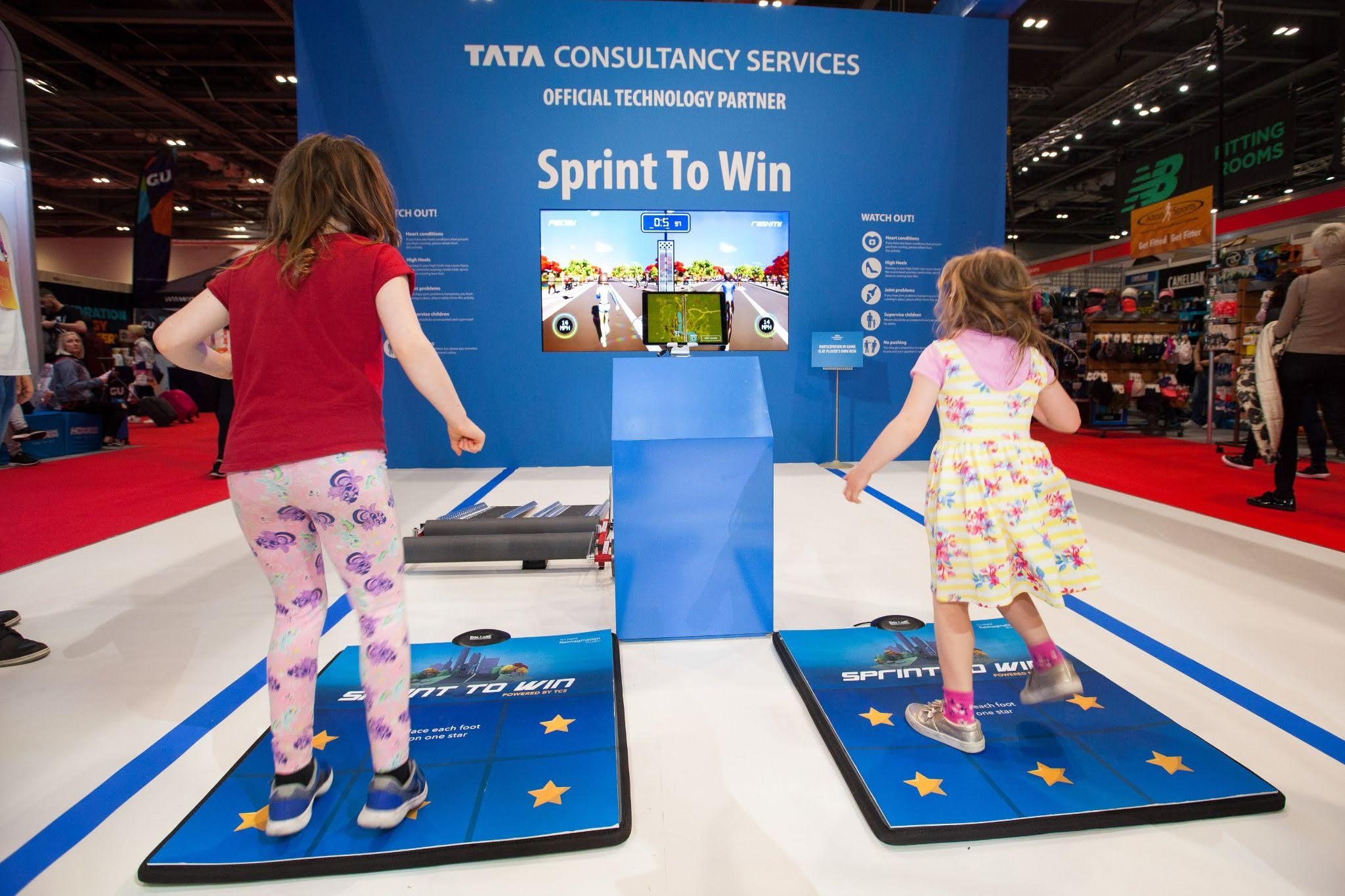 Two kids racing side-by-side on the Sprint to Win pads at the NYC Marathon expo